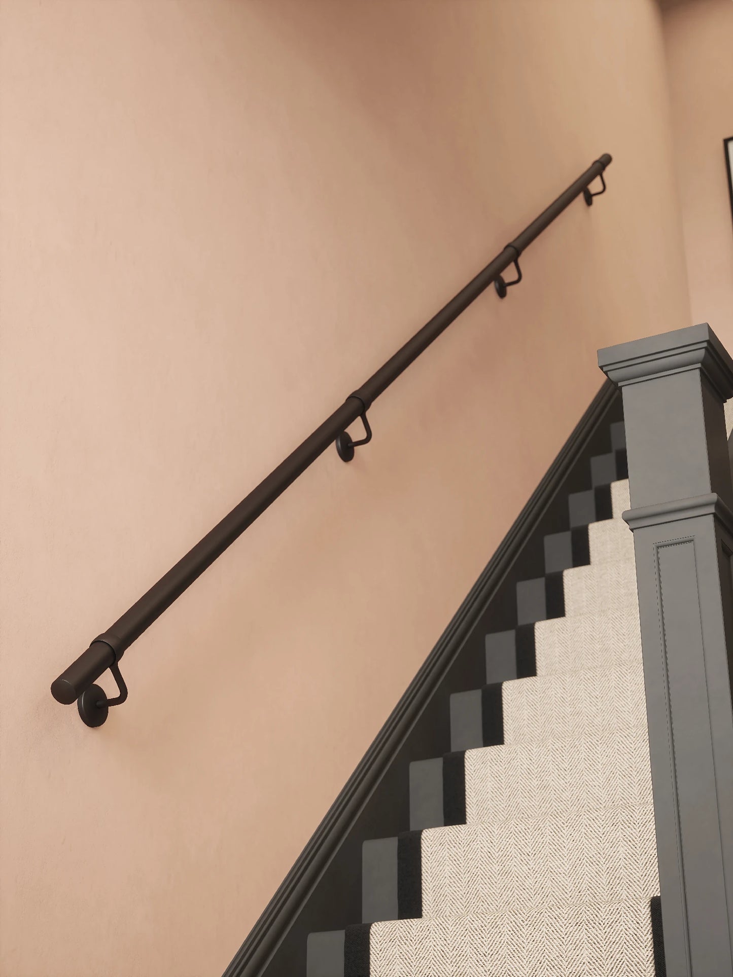 Matt black 3.6M straight run handrail installed on staircase wall, angled view