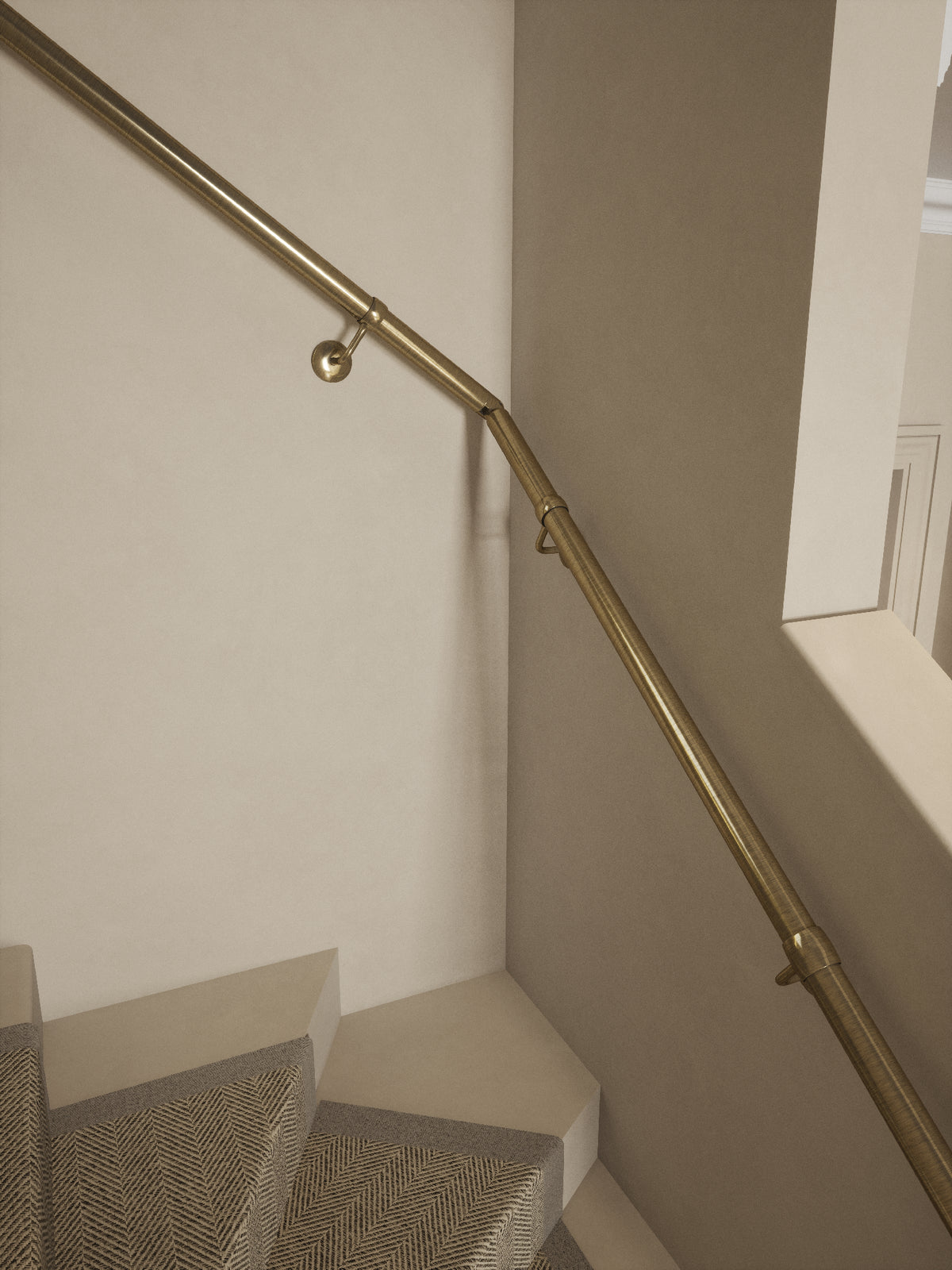 Close-up of the Loxley Antique Brass single winder handrail turning at the winder step