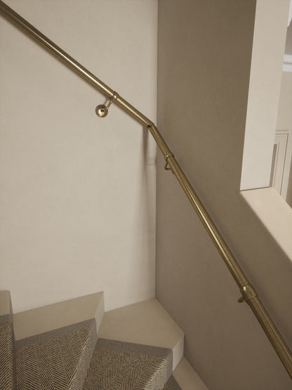 Close-up of the Loxley Antique Brass single winder handrail turning at the winder step
