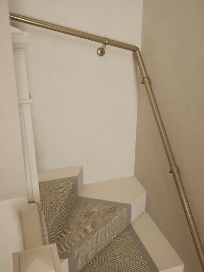 Top-down view of the Loxley Antique Brass single winder handrail following the winder turn