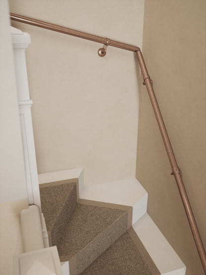 Top-down view of the Sambourne Antique Copper single winder handrail following the winder turn