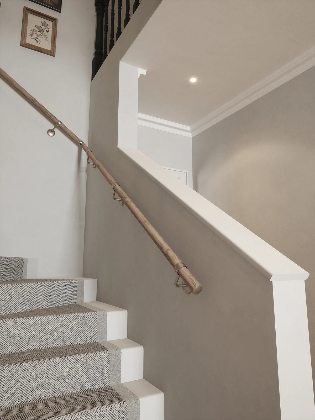 Oversley Walnut Single Winder Handrail with Harbury Brushed Silver brackets mounted on a grey wall beside carpeted stairs