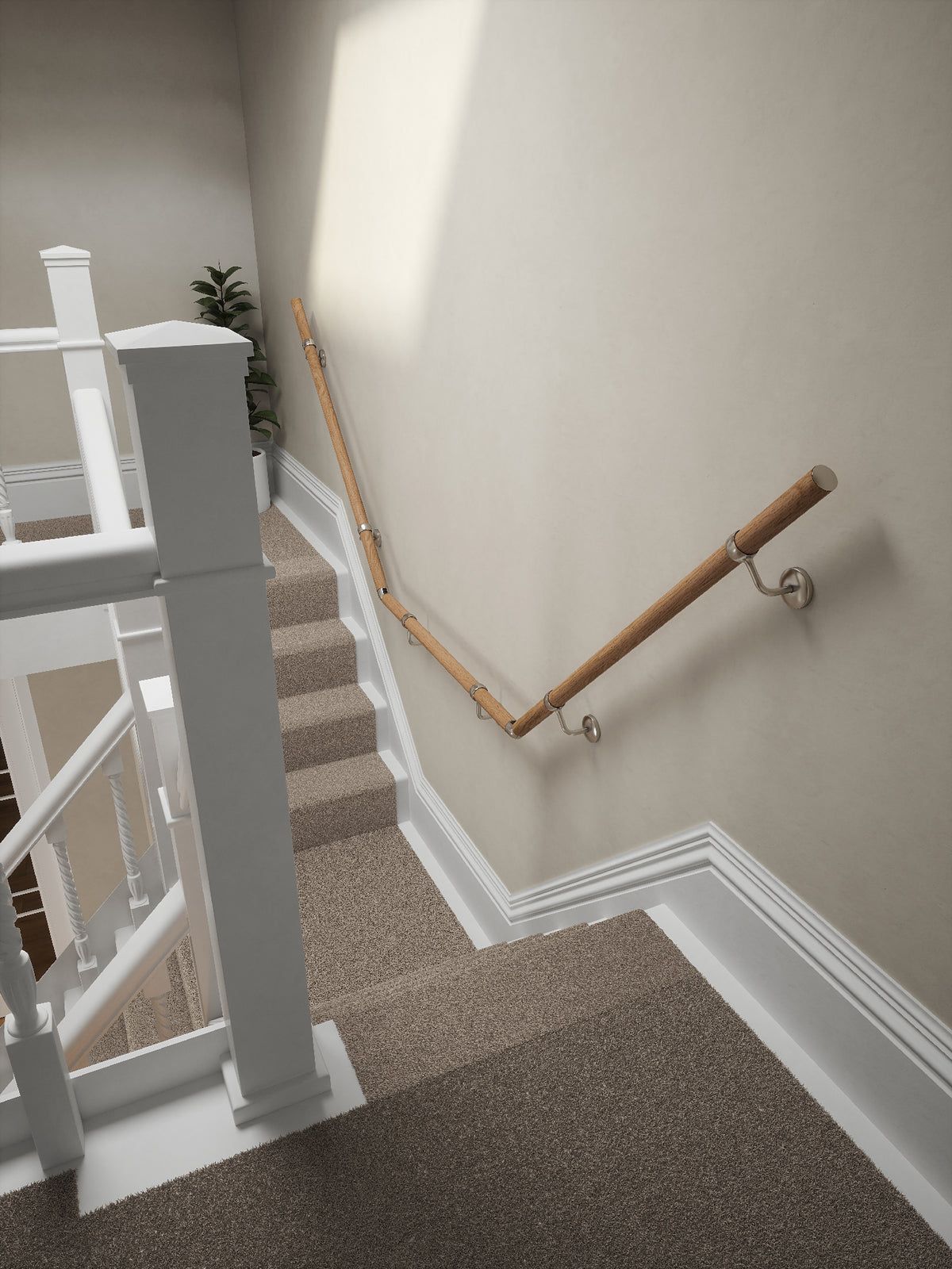 Stoneleigh Red Oak T-shape handrail with silver fittings running down the staircase wall