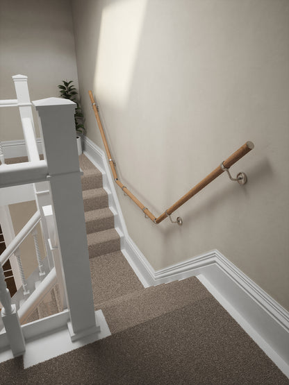 Stoneleigh Red Oak T-shape handrail with silver fittings running down the staircase wall