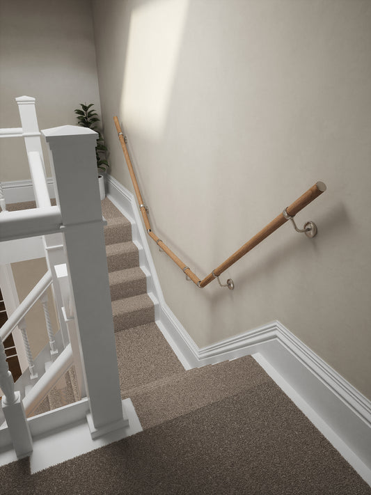 Stoneleigh Red Oak T-shape handrail with silver fittings running down the staircase wall
