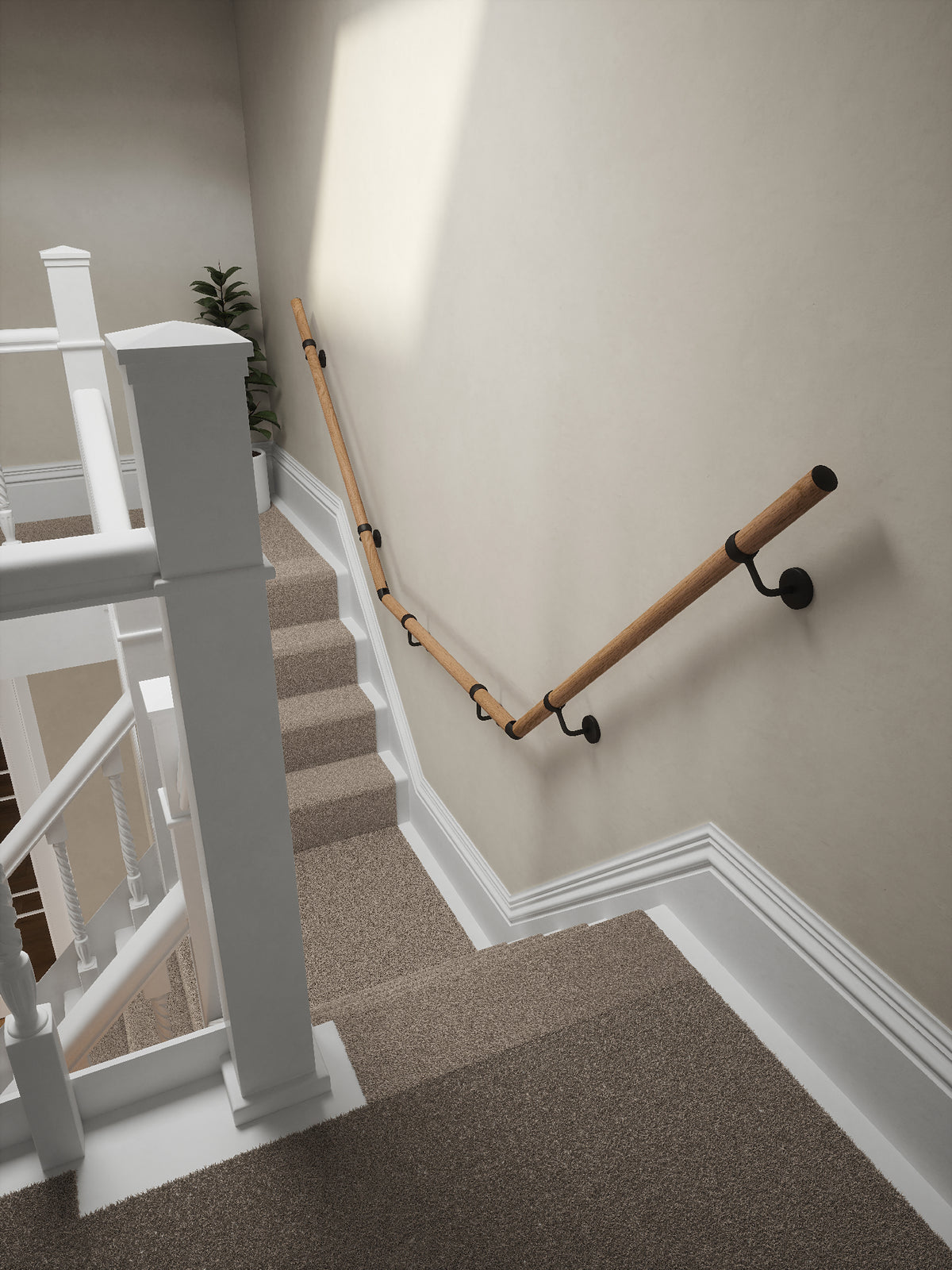 Stoneleigh Red Oak T-shape handrail with matt black fittings running down the staircase wall