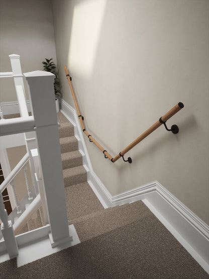 Stoneleigh Red Oak T-shape handrail with matt black fittings running down the staircase wall