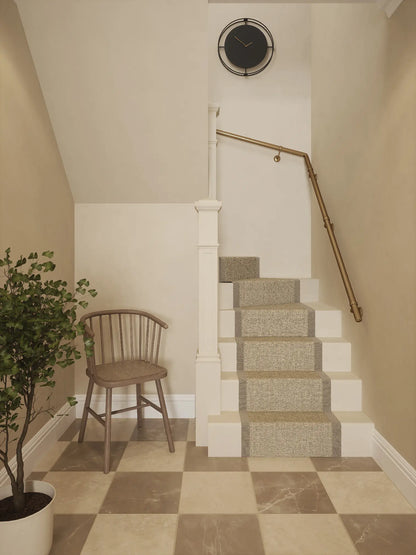 Antique brass 40mm double winder handrail installed on staircase wall, front view