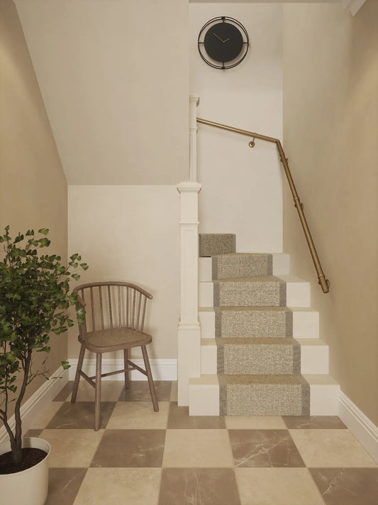 Antique brass 40mm double winder handrail installed on staircase wall, front view