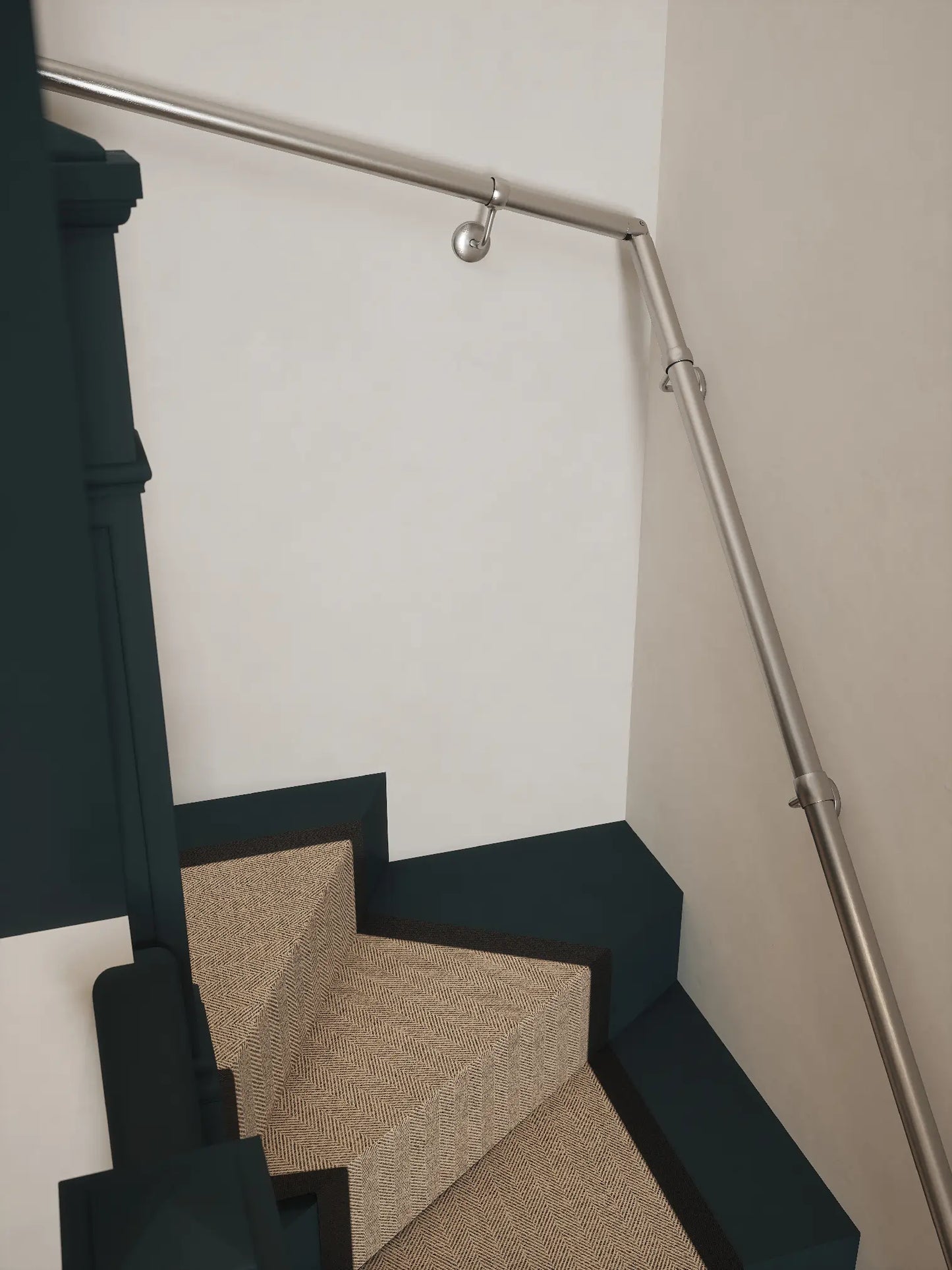 Brushed silver 40mm double winder handrail following staircase turn, angled view