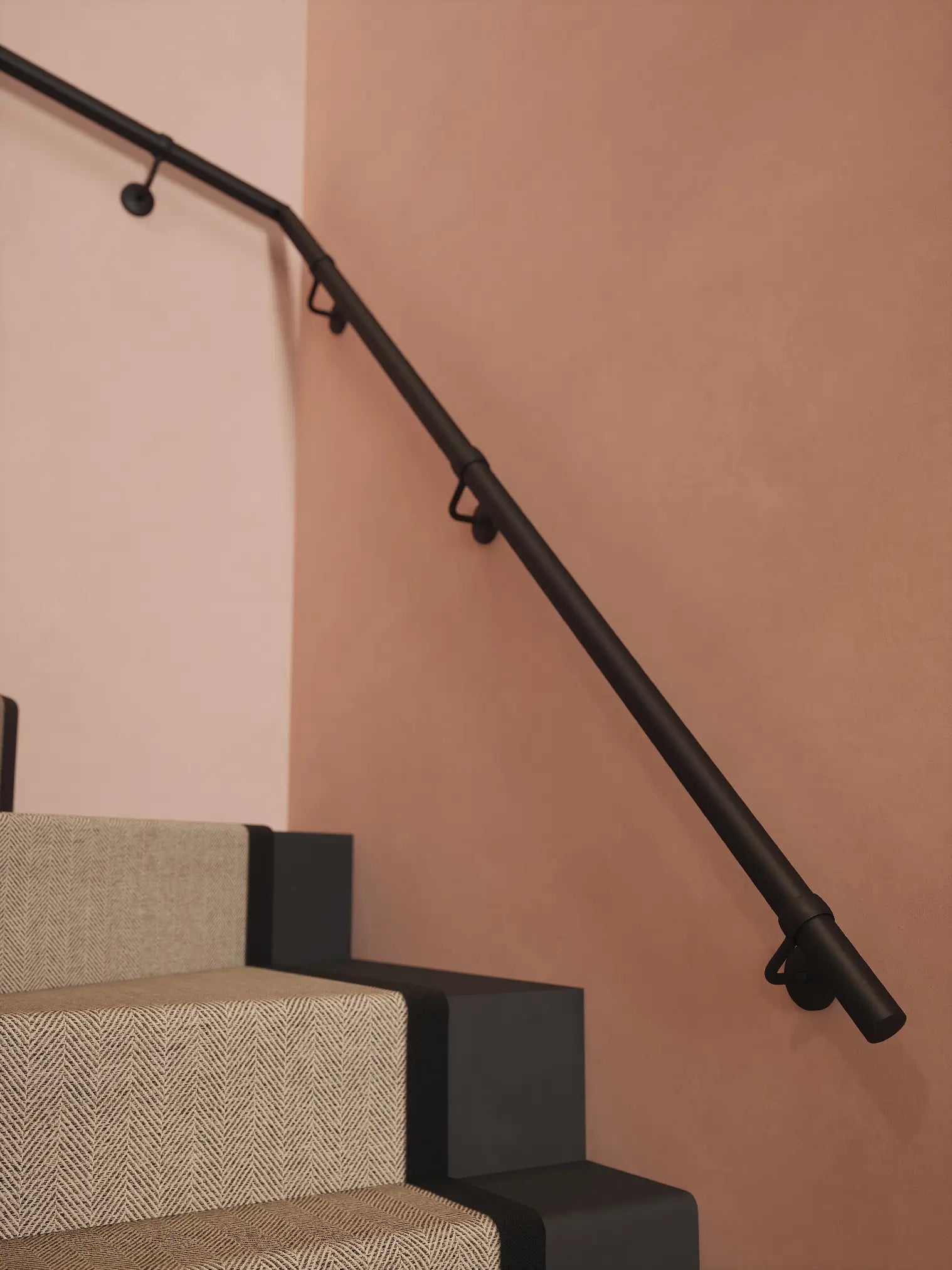 Matt black 40mm double winder handrail following staircase turn, angled view