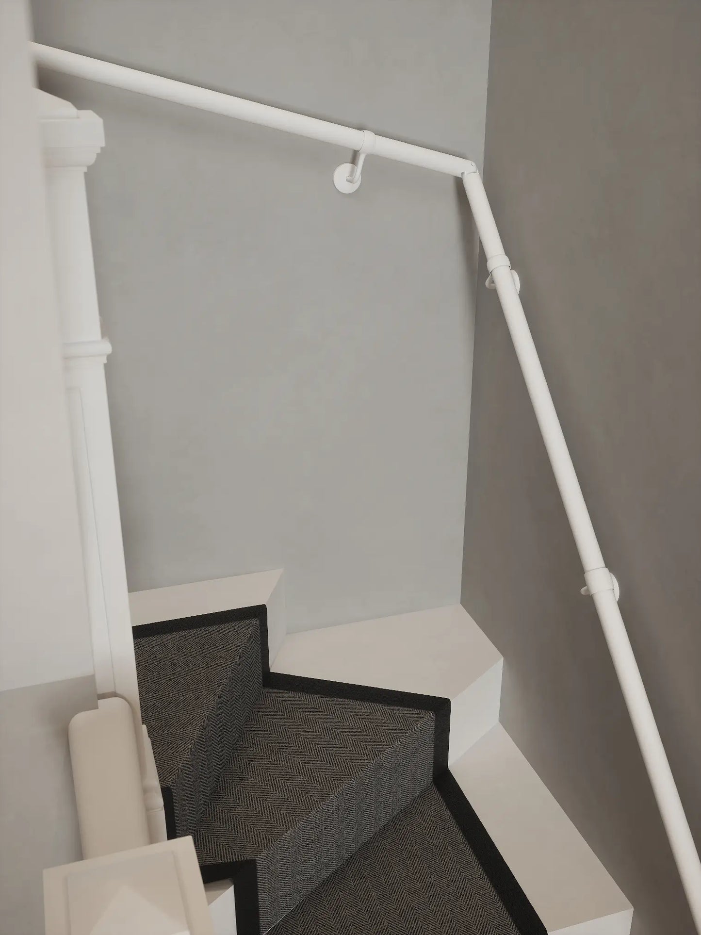 Matt white 40mm double winder handrail following staircase turn, angled view