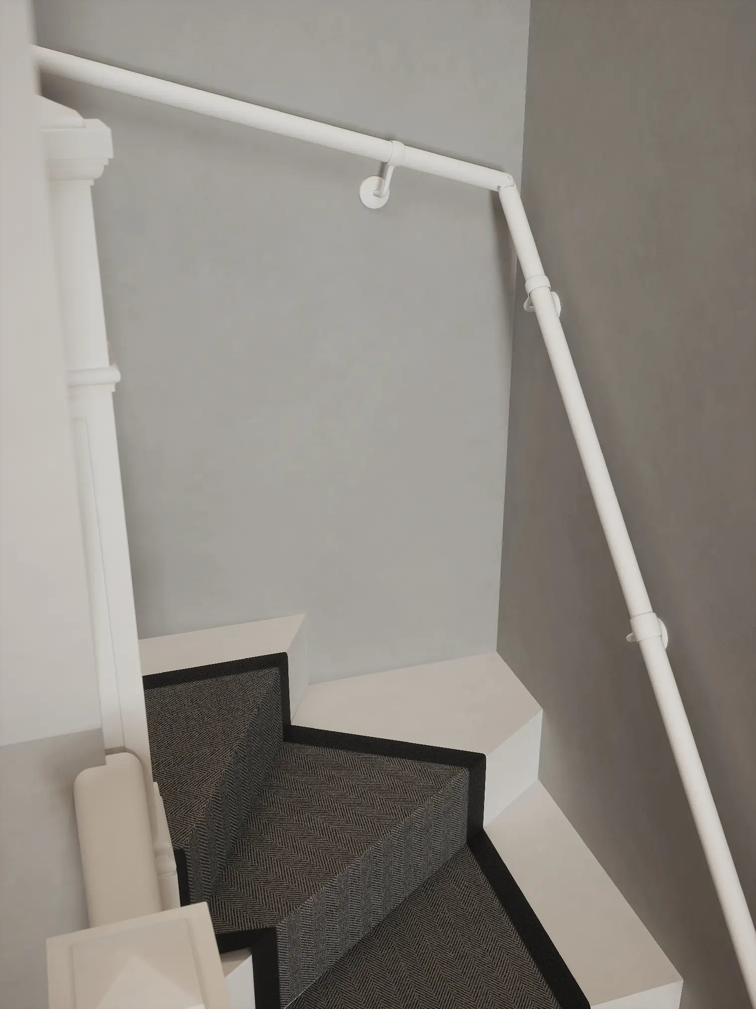 Matt white 40mm double winder handrail following staircase turn, angled view