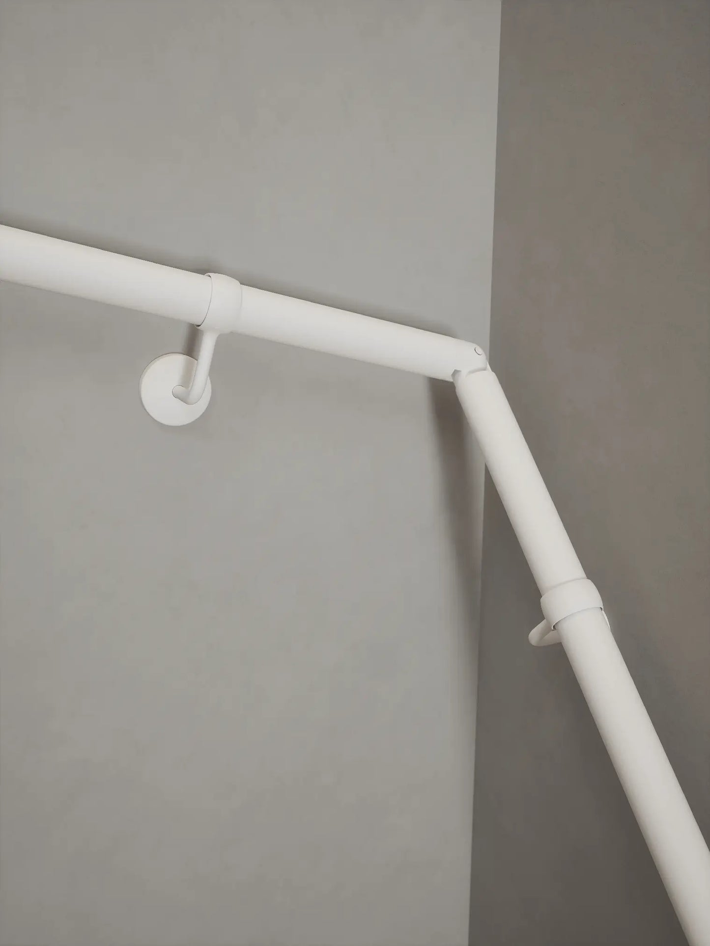 Matt white 40mm double winder handrail, close-up view of angled joint