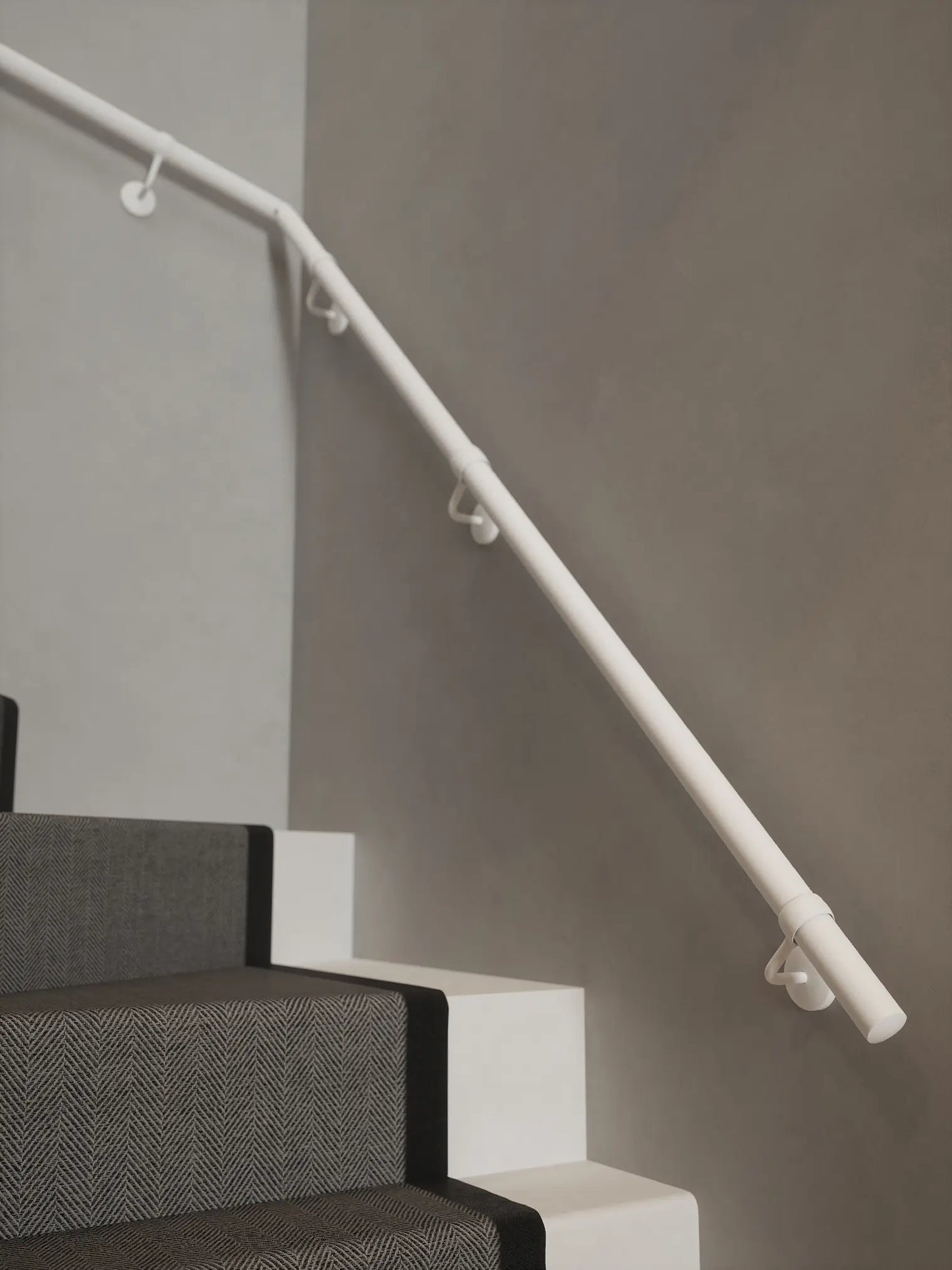 Matt white 40mm double winder handrail mounted on staircase wall, side view