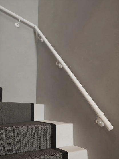 Matt white 40mm double winder handrail mounted on staircase wall, side view