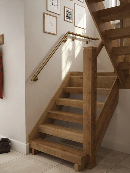 Antique brass 40mm half turn handrail fitted to staircase wall, angled view
