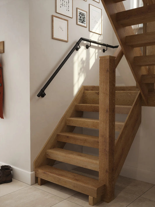 Matt black half turn handrail fitted to staircase wall, angled view