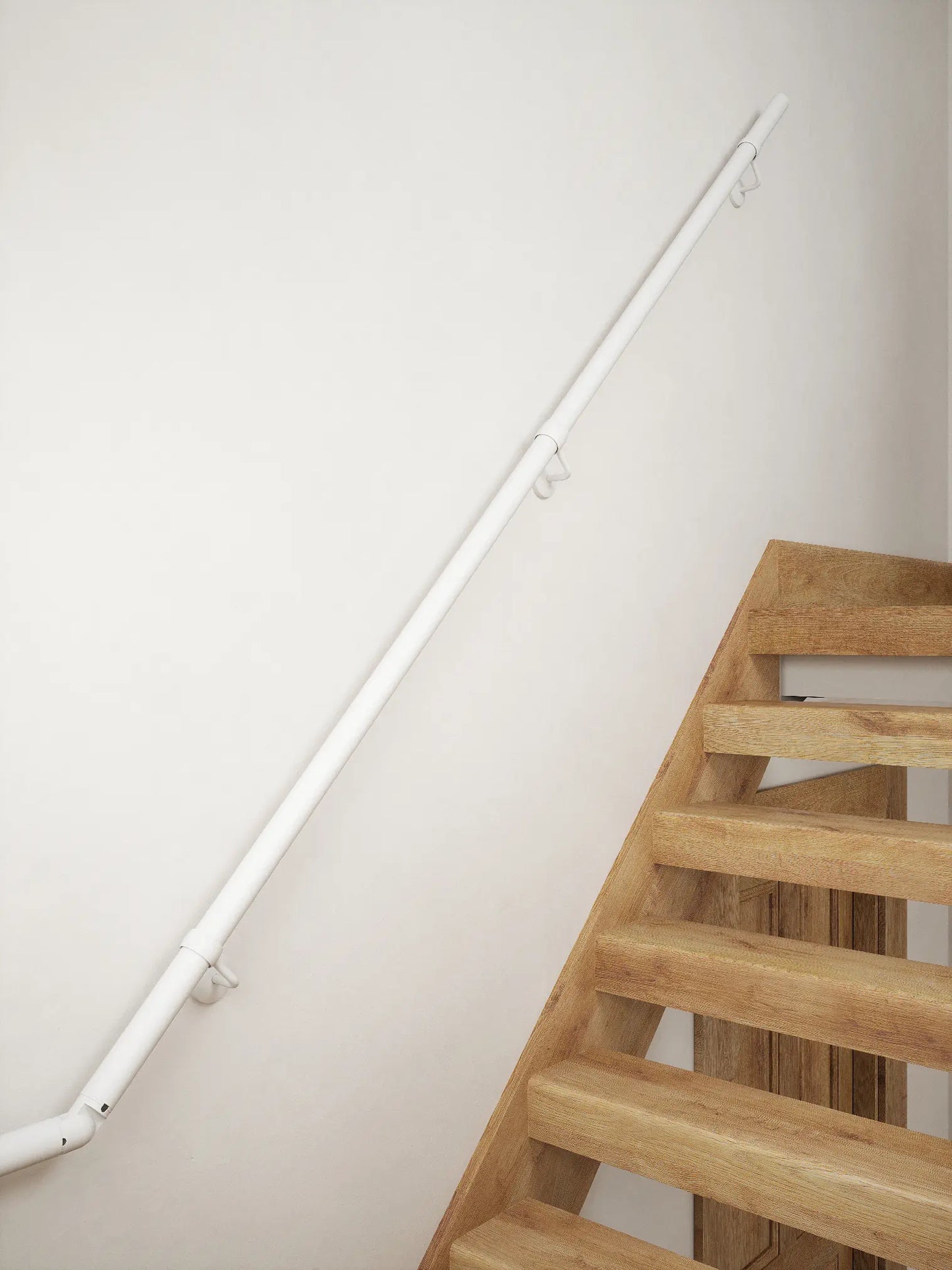 Matt white 40mm half turn handrail mounted on staircase wall, side view