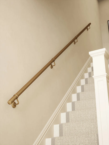 Antique brass 3.6m straight run handrail installed on staircase wall, angled view