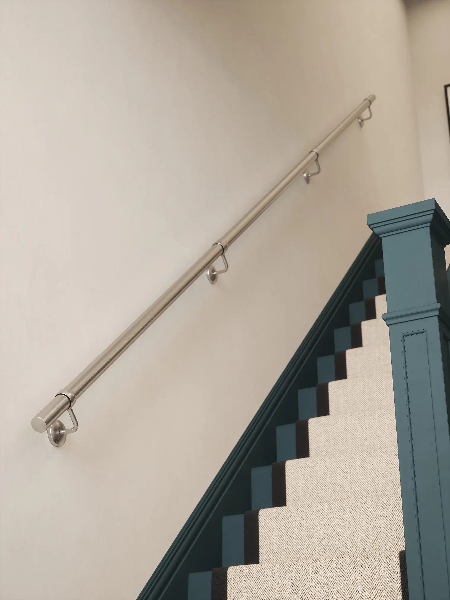 Brushed silver3.6m straight run handrail installed on staircase wall, angled view