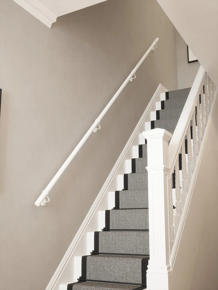 Matt white 40mm straight run handrail installed on staircase wall
