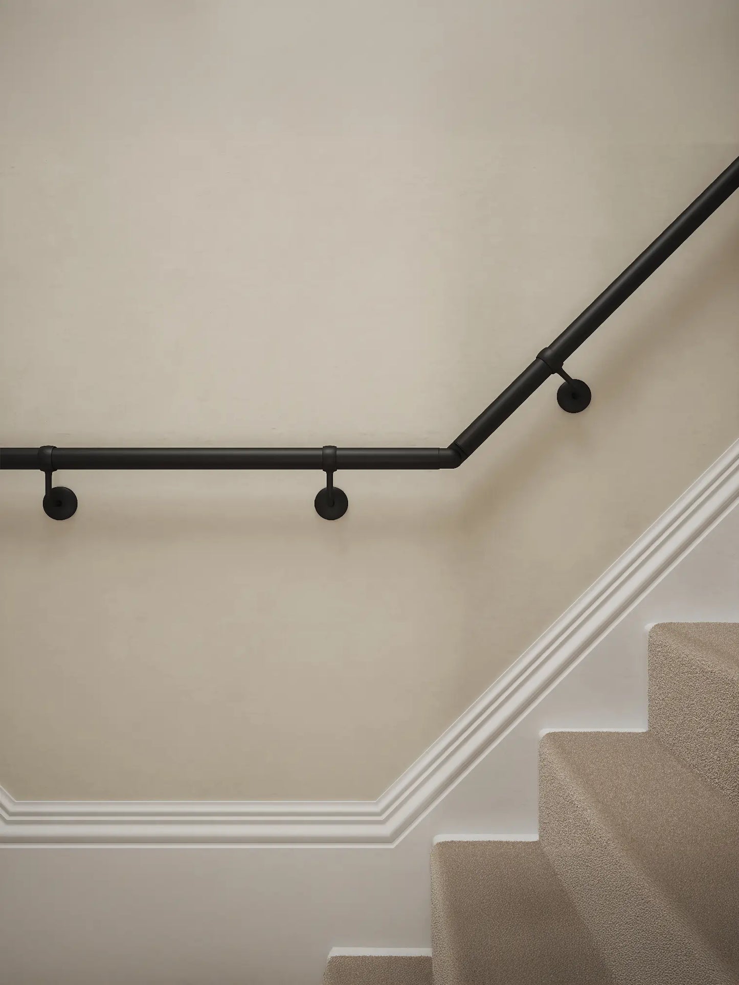 Close-up of Kineton Matt Black wall-mounted handrail with brackets on a T-shape staircase – Handrails Direct UK supplier of modular indoor handrails and fittings