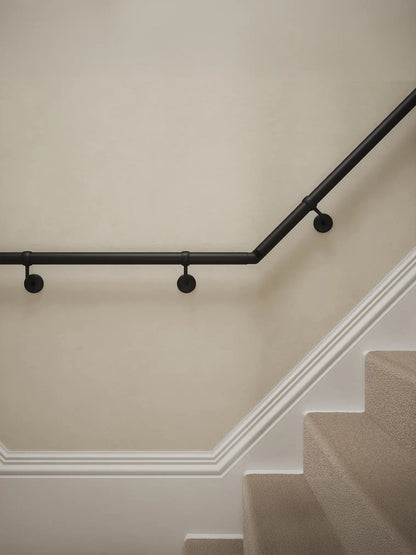 Close-up of Kineton Matt Black wall-mounted handrail with brackets on a T-shape staircase – Handrails Direct UK supplier of modular indoor handrails and fittings
